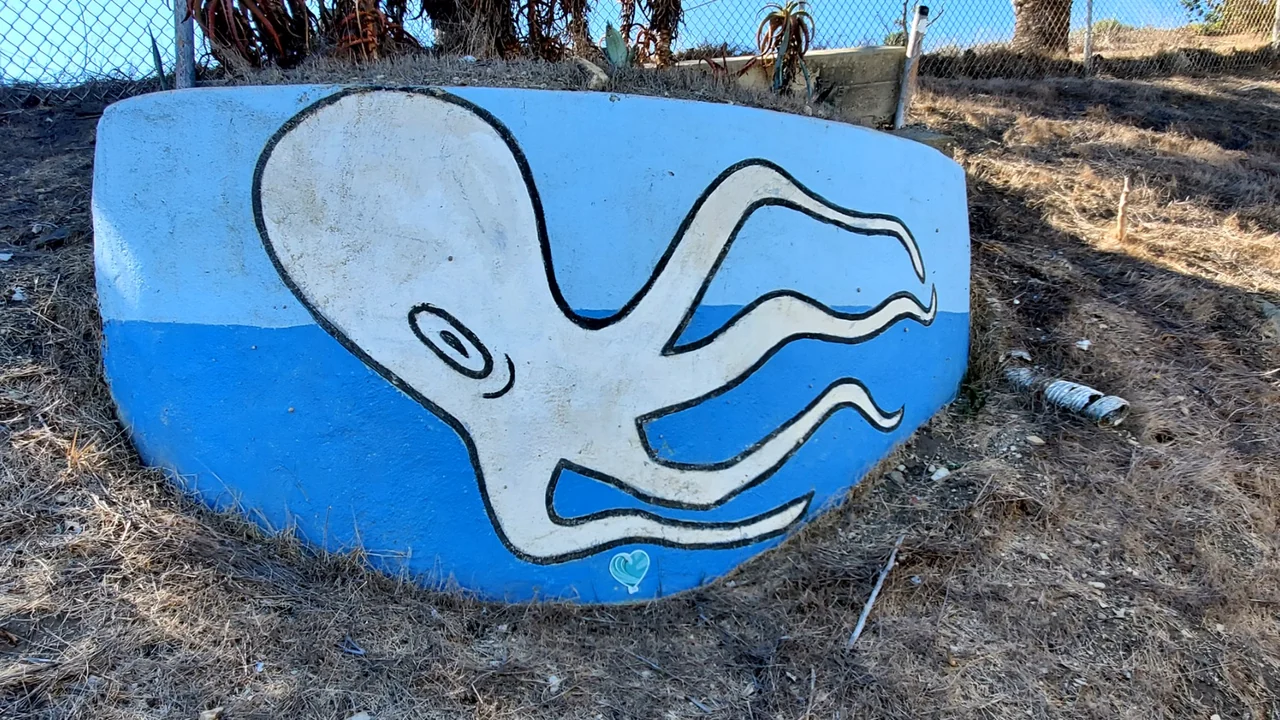 White one-eyed octopus mural on blue concrete along Gaffey Street in San Pedro